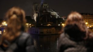 اشخاص يشاهدون الدخان والنيران تتصاعد من كاتدرائية نوتردام في باريس، 16 ابريل 2019 (Zakaria ABDELKAFI / AFP)