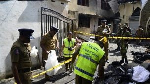 عناصر امن وعناصر شرطة يفحصون الحطام خارج كنيسة بعد تفجير في باتيكالوا، شرق سريلانكا، 21 ابريل 2019 (LAKRUWAN WANNIARACHCHI / AFP)