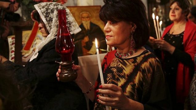 المصلون الأرثوذكس المسيحيون يحملون شموعا خلال حفل عيد الفصح في كنيسة القديس بورفيريوس في مدينة غزة، السبت، 15 أبريل، 2017. (AP Photo / Adel Hana)
