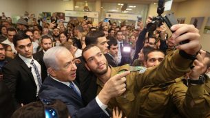 رئيس الوزراء بنيامين نتنياهو يلتقط صورة مع جندي خلال حدث للجنود الوحيدين في تل ابيب، 24 يناير 2019 (Marc Israel Sellem/Pool/Flash90)