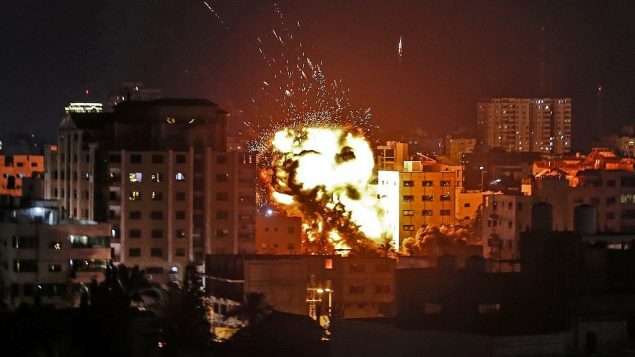 انفجار بين مبان خلال غارة جوية إسرائيلية على القطاع الساحلي ردا على إطلاق صواريخ من القطاع، 4 مايو، 2019.  (Mahmud Hams / AFP)