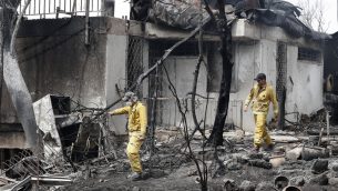 رجال اطفاء يفحصون منزلا تضرر نتيجة حريق جاء خلال موجة حر شديد في قرية ميفو مودعيم، في مركز اسرائيل، 24 مايو 2019 (JACK GUEZ / AFP)