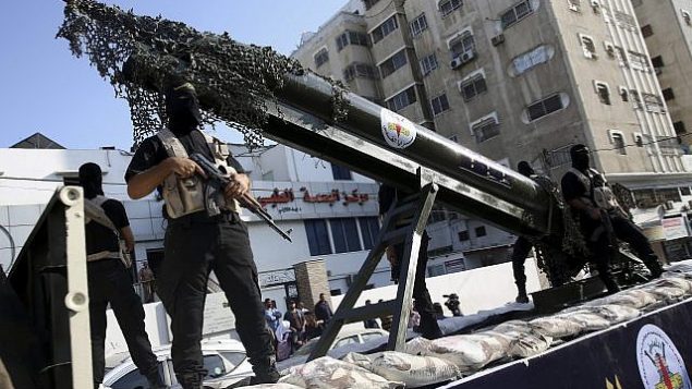 عناصر في ’سرايا القدس’، الجناح العسكري لحركة الجهاد الإسلامي الفلسطينية، خلال مسيرة مع مجسم صاروخ على شاحنة في 4 أكتوبر، 2018.  (AP Photo/Adel Hana)