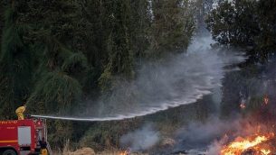 رجال الإطفاء يحاولون إخماد حريق بالقرب من كيبوتس هرئيل، 23 مايو، 2019.  (Yonatan Sindel/Flash90)