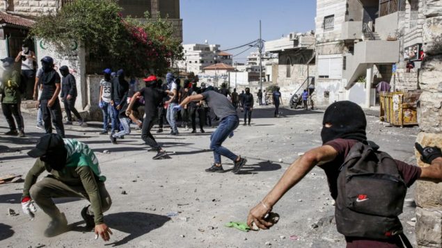 فلسطينيون يرشقون الحجارة خلال اشتباكات مع الشرطة في حي العيساوية في القدس الشرقية، 28 يونيو 2019 (Hazem Bader/AFP)