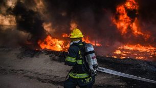 رجل إطفاء يعمل على اخماد حريق ناجم عن بالونات حارقة تم إطلاقها من قطاع غزة في جنوب إسرائيل، 27 يونيو، 2019.  (Fire and Rescue Services)