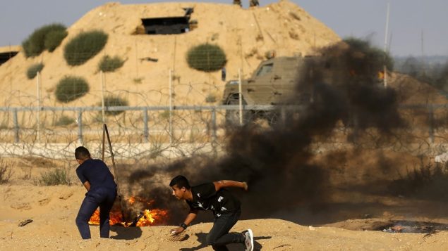 صورة توضيحية: منظاهرون فلسطينيون يحرقون إطارات خلال اشتباكات بين المتظاهرين الفلسطينيين والقوات الإسرائيلية عبر السياج الشائك خلال مظاهرة حدودية بالقرب من رفح جنوب قطاع غزة في 19 يوليو، 2019. (SAID KHATIB / AFP) صورة توضيحية: منظاهرون فلسطينيون يحرقون إطارات خلال اشتباكات بين المتظاهرين الفلسطينيين والقوات الإسرائيلية عبر السياج الشائك خلال مظاهرة حدودية بالقرب من رفح جنوب قطاع غزة في 19 يوليو، 2019. (SAID KHATIB / AFP)