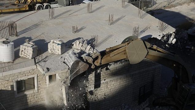 هذه الصورة تم التقاطها في 22 يوليو، 2019 وتظهر قوى أمن إسرائيلية تقوم بهدم مبان فلسطينية لا تزال قيد البناء بعد صدور إشعارات بهدمها في منطقة وادي الحمص المتاخمة لحي صور باهر في القدس الشرقية. ( Ahmad GHARABLI / AFP)