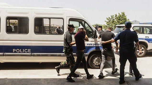 سياح إسرائيليون، مشتبهون باغتصاب فتاة بريطانية (19 عاما) في أيا نابا، يغادرون قاعة المحكمة فيمدينة بارليمني السياحية شرق جزيرة قبرص، 26 يوليو، 2019. (Iakovos Hatzistavrou / AFP)