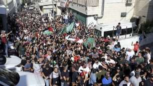 مشيعون يرفعون الأعلام الفلسطينية وأعلام حماس خلال جنازة الشاب الفلسطيني محمد عبيد (20 عاما)، الذي قُتل في 27 يناير في مواجهات مع الشرطة الإسرائيلية، القدس الشرقية، 1 يوليو، 2019.   (AP Photo/Mahmoud Ilean)