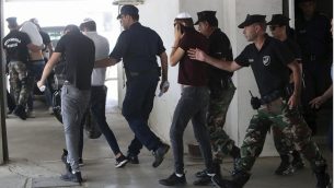 مشتبه بهم اسرائيليون يغطون وجوههم بمساعدة ملابسهم اثناء وصولهم الى محكمة فاماغوستا في بلدة بارالامني في قبرص، 26 يوليو 2019 (AP Photo/Petros Karadjias)