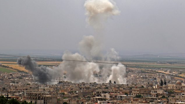 الدخان يتصاعد في اعقاب قصف مفترض من قبل الحكومة السورية في بلدة خان سيخون في محافظة ادلب، 23 مايو 2019 (Anas Al-Dyab/AFP)