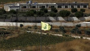 صورة تم التقاطها في 26 أغسطس، 2019، بالقرب من موشاف أفيفيم على الحدود الشمالية لإسرائيل يظهر فيها علم حزب الله في قرية عيترون اللبنانية.  (Jalaa Marey/AFP)