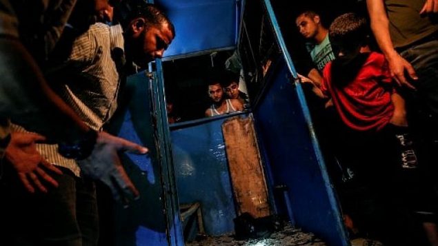 فلسطينيون يتفرجون على كشك مدمر لحاجز شرطة وقع فيه انفجار في مدينة غزة، 27 أغسطس، 2019.  (Photo by MAHMUD HAMS / AFP)