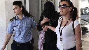 شرطيتان ترافقان شابة بريطانية (19 عاما)، وسط، خارج محكمة فاماغوستا في مدينة بالارميني القبرصية، 29 يوليو، 2019.  (AP/Petros Karadjias)