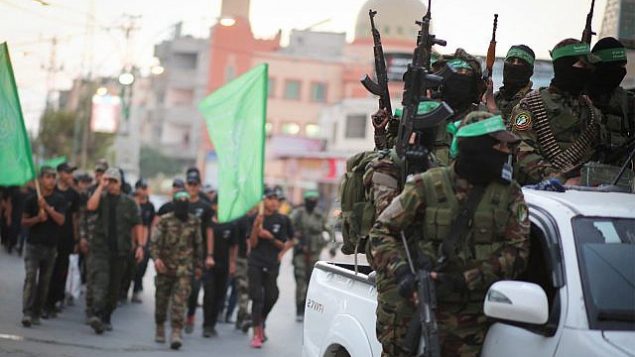 عناصر في كتائب عز الدين القسام، الجناح العسكري لحركة حماس، يشاركون في مسيرة في مدينة غزة، 25 يوليو، 2019. (Hassan Jedi/Flash90)