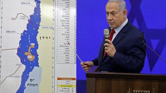 رئيس الوزراء بنيامين نتنياهو يقف أمام خريطة لغور الأردن خلال إلقاء خطاب في رمان غان، 10 سبتمبر، 2019. (Menahem Kahana/AFP)