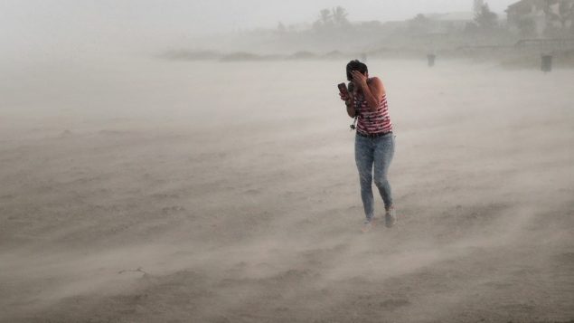 سيدة تحاول الاختباء من الرياح والامطار خلال اعصار دوريان في فلوريدا، 2 سبتمبر 2019 (Scott Olson/Getty Images/AFP)