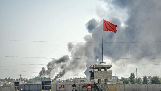 صورة تم التقاطها في بلدة أقجة قلعة على الحدود التركية مع سوريا في 10 أكتوبر، 2019 يظهر فيها الدخان وهو يتصاعد في بلدة تل أبيض السورية بعد سقوط قذيفة في حديقة مبنى حكومي تركي في أقجة قلعة. (BULENT KILIC / AFP)