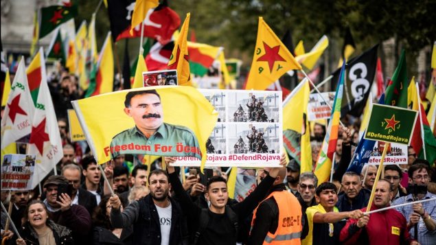 أشخاص يرفعون أعلاما ولافتات مناصرة للأكراد في باريس، 12 أكتوبر، 2019، خلال تظاهرة مؤيدة للمقاتلين الأكراد واحتجاج على استمرار التدخل العسكري التركي على البلدات الحدودية التي يسيطر عليها الأكراد في شمال شرق سوريا، في اليوم الرابع من الهجوم الذي أثار إدانات دولية، حتى من واشنطن.   (Martin BUREAU / AFP)