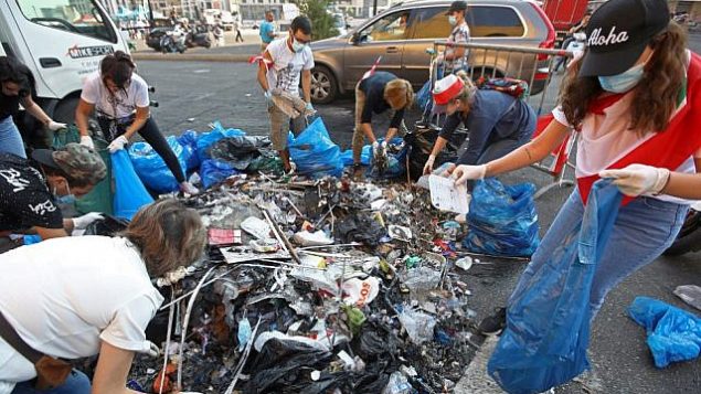 متظاهرون لبنانيون ينظفون القمامة من شوارع وسط العاصمة بيروت بعد ليلة من الاحتجاجات على زيادة الضرائب والفساد الحكومي، 21 أكتوبر 2019 (ANWAR AMRO / AFP)
