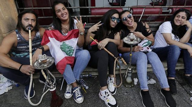 محتجون مناهضون للحكومة يدخنون ارجيلة خلال مظاهرة في بيروت، لبنان، 20 أكتوبر 2019. (AP Photo / Hassan Ammar)