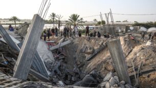 فلسطينيون يحتشدون حول أنقاض منزل يقول الجيش الإسرائيلي إنه استُخدم كمخبأ للأسلحة لحركة ’الجهاد الإسلامي’، والذي دُمر في غارة جوية إسرائيلية في خان يونس بجنوب قطاع غزة، 13 نوفمبر، 2019. (SAID KHATIB / AFP)