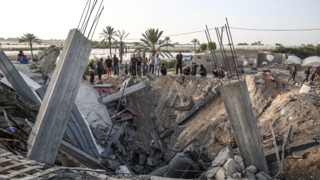 فلسطينيون يحتشدون حول أنقاض منزل يقول الجيش الإسرائيلي إنه استُخدم كمخبأ للأسلحة لحركة ’الجهاد الإسلامي’، والذي دُمر في غارة جوية إسرائيلية في خان يونس بجنوب قطاع غزة، 13 نوفمبر، 2019. (SAID KHATIB / AFP)
