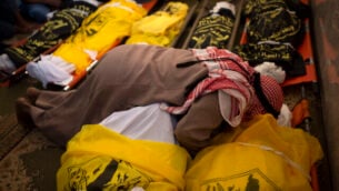 فلسطيني يودع جثامين  رسمي أبو ملحوس وسبعة من أفراد عائلته الذين قُتلوا في غارة ليلية إسرائيلية استهدفت منزلهم، في مسجد خلال مراسم جنازتهم، في دير البلح، وسط قطاع غزة، 14 نوفمبر، 2019.  (AP Photo/Khalil Hamra)