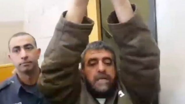 صدقي المقت، المسجون بتهمة التجسس لصالح سوريا، يرفع ذراعيه وهو يتحدث إلى صحفيين، 27 مارس 2015 (Screen capture: Channel 2)