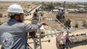 توضيحية: عمال كهرباء فلسطينيين يتفقدون منشآت كهرباء في مدينة رفج بجنوب غزة،  25 يونيو، 2019.(Said Khatib/AFP)