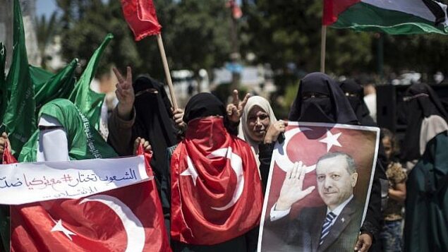 مناصرون فلسطينيون لحركة ’حماس’ يحملون صورا للرئيس التركي، رجب طيب إردوغان، ويهتفون شعارات ضد محاولة انقلاب عسكري في تركيا، خلال تظاهرة في مدينة غزة، 17 يوليو، 2016. (AFP/MAHMUD HAMS)