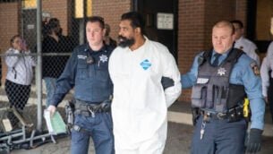ضباط شرطة رامابو يرافقون غرافتون توماس من مجلس مدينة رامابو إلى سيارة شرطة، 29 ديسمبر 2019، في رامابو ، نيويورك. (AP Photo / Julius Constantine Motal)