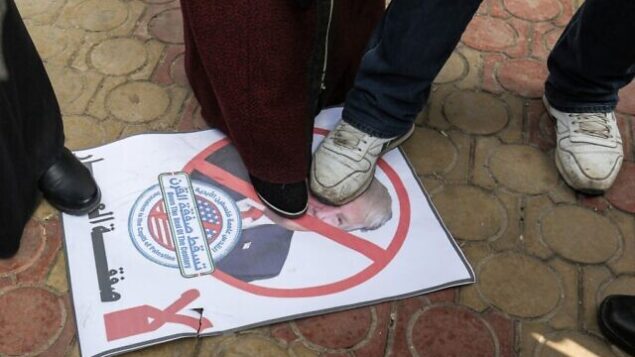 متظاهرون فلسطينيون يدوشون على صورة للرئيس الأمريكي دونالد ترامب خلال تظاهرة ضد إعلانه المتوقع عن خطته للسلام، في رفح بجنوب قطاع غزة، 28 يناير، 2020. (SAID KHATIB / AFP)
