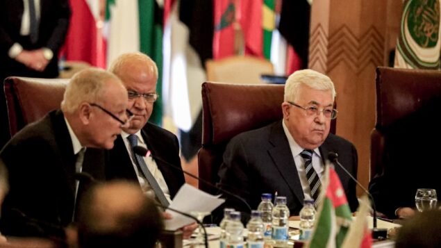 رئيس السلطة الفلسطينية محمود عباس (يمين) والأمين العام لمنظمة التحرير الفلسطينية صائب عريقات (مركز) ينظران إلى الأمين العام لجامعة الدول العربية أحمد أبو الغيط (يسار) بينما يقرأ بياناً خلال اجتماع طارئ لجامعة الدول العربية لمناقشة خطة اقتراح الرئيس الأمريكي دونالد ترامب للسلام، في مقر الجامعة العربية في العاصمة المصرية القاهرة، 1 فبراير، 2020. (Khaled Desouki/AFP)
