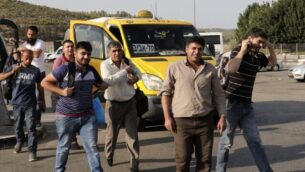 صورة تم التقاطها من الجانب الإسرائيلي لحاجز ترقوميا  بالقرب من مدينة كريات غات بجنوب البلاد يظهر فيها عمال فلسطينيون وهم يجتازون الحاجز لدخول إسرائيل والوصول إلى أعمالهم في 14 نوفمبر، 2019. (HAZEM BADER / AFP)