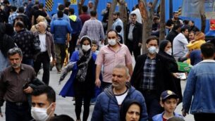 إيرانيون، بعضهم يضع أقنعة واقية، يتجمعون داخل البازار الكبيؤ في طهران في خضم أزمة انتشار فيروس كورونا، 18 مارس، 2020. (AFP)