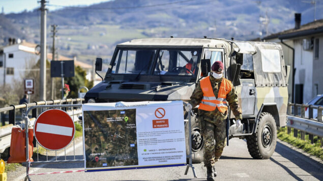 جندي من الجيش الإيطالي يغلق طريقًا يؤدي إلى قرية فو إيوغانيو، في منطقة فينيتو بشمال إيطاليا، في 28 فبراير 2020. (Claudio Fulan/LaPresse via AP) جندي من الجيش الإيطالي يغلق طريقًا يؤدي إلى قرية فو إيوغانيو، في منطقة فينيتو بشمال إيطاليا، في 28 فبراير 2020. (Claudio Fulan/LaPresse via AP)