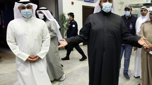 وزير الصحة الكويتي الشيخ باسل الصباح (يمين) يتحدث مع وسائل الإعلام في مطار الشيخ سعد في مدينة الكويت، 22 فبراير، 2020، خلال انتظار كويتيين عائدين من إيران نقلهم إلى المستشفى لإجراء فحوصات فيروس كورونا لهم.  (YASSER AL-ZAYYAT / AFP)