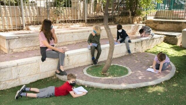 تلاميذ إسرائيليون يرتدون أقنعة واقية مع عودتهم إلى المدرسة للمرة الأولى منذ تفشي فيروس كورونا، 3 مايو، 2020 في القدس. (Olivier Fitoussi / Flash90)