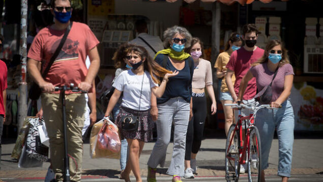 أشخاص يضعون أقنعة واقية في تل أبيب، 8 مايو، 2020. (Miriam Alster/Flash90) أشخاص يضعون أقنعة واقية في تل أبيب، 8 مايو، 2020. (Miriam Alster/Flash90)