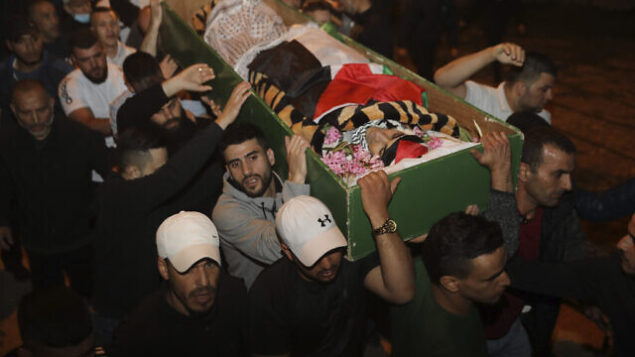 رجال يحملون جثمان إياد الحلاق الذي قُتل برصاص الشرطة الإسرائيلية في البلدة القديمة بالقدس، الأحد، 31 مايو، 2020.  (AP Photo/Mahmoud Illean)