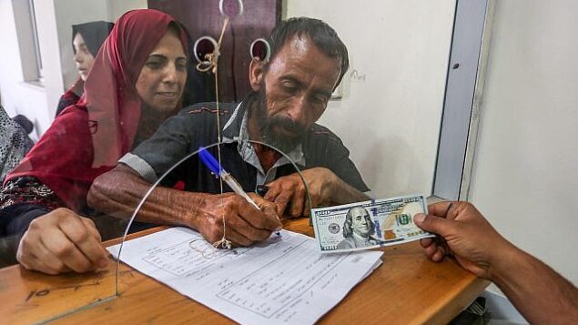 فلسطينيون يستلمون مساعدات مالية من قطر في مكتب بريد بمدينة غزة، 20 يونيو، 2019.  (Abed Rahim Khatib/Flash90)