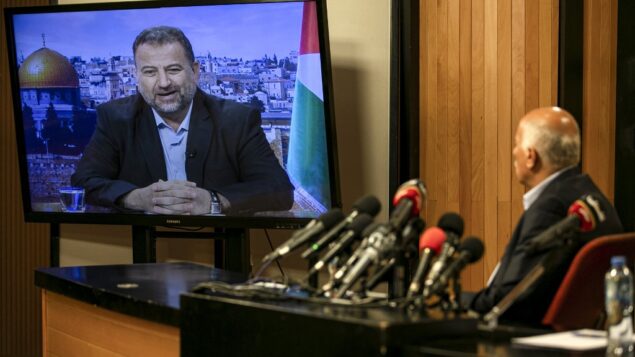 المسؤول الرفيع في فتح جبريل رجوب، في مدينة رام الله بالضفة الغربية، خلال اجتماع عبر الفيديو مع نائب رئيس حماس صالح العاروري (على الشاشة من بيروت) لمناقشة خطة إسرائيل لضم أجزاء من الضفة الغربية، 2 يوليو 2020. (ABBAS MOMANI / AFP)