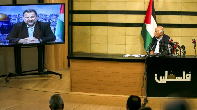 المسؤول الرفيع في فتح جبريل رجوب، في مدينة رام الله بالضفة الغربية، خلال اجتماع عبر الفيديو مع نائب رئيس حماس صالح العاروري (على الشاشة من بيروت) لمناقشة خطة إسرائيل لضم أجزاء من الضفة الغربية، 2 يوليو 2020. (ABBAS MOMANI / AFP) المسؤول الرفيع في فتح جبريل رجوب، في مدينة رام الله بالضفة الغربية، خلال اجتماع عبر الفيديو مع نائب رئيس حماس صالح العاروري (على الشاشة من بيروت) لمناقشة خطة إسرائيل لضم أجزاء من الضفة الغربية، 2 يوليو 2020. (ABBAS MOMANI / AFP)