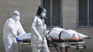 فريق طبي فلسطيني ينقل جثمان شخص توفى نتيجة مرض كوفيد-19 من المستشفى العسكري في مدينة نابلس بالضفة الغربية، 9 يوليو 2020. (JAAFAR ASHTIYEH / AFP)