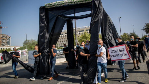 أصحاب صالات المناسبات في إسرائيل يحتجون خارج مكتب رئيس الوزراء في القدس مع عريشة زواج سوداء، 26 يوليو 2020 (Yonatan Sindel / Flash90)