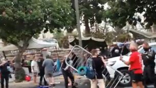 عناصر من الشرطة ومراقبو بلدية يشتبكون في متظاهرين بالقرب من مقر الإقامة الرسمي لرئيس الوزراء بنيامين نتنياهو في القدس، 13 يوليو، 2020. (Screen grab/Twitter)