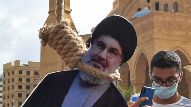 مجسم لحسن نصر الله، زعيم تنظيم حزب الله اللبناني، معلق بحبل مشنقة من قبل متظاهرين لبنانيين في وسط بيروت، خلال مظاهرة ضد القيادة السياسية، 8 أغسطس 2020 (AFP)