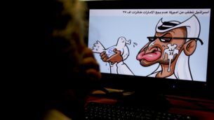 امرأة تنظر إلى رسم كاريكاتوري لرسام الكاريكاتير الأردني عماد الحجاج يصور زعيم دولة الإمارات العربية المتحدة الشيخ محمد بن زايد آل نهيان وهو يحمل حمامة عليها علم إسرائيل، وتبصق في وجهه، وتشير كتابة عربية إلى معارضة إسرائيل لبيع طائرات أمريكية من طراز إف-35 للإمارات، 27 أغسطس 2020 (AFP)